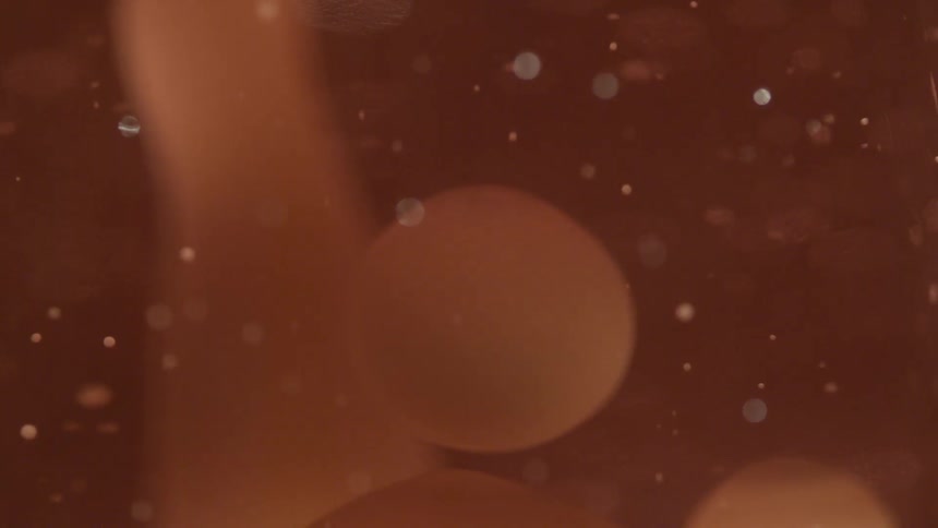 Slow motion view of bubbles in pink liquid