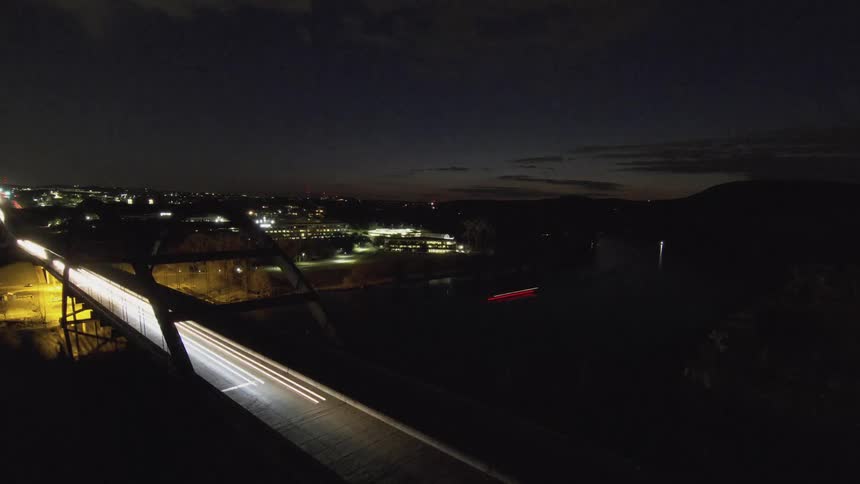 Vehicles cross a bridge at night