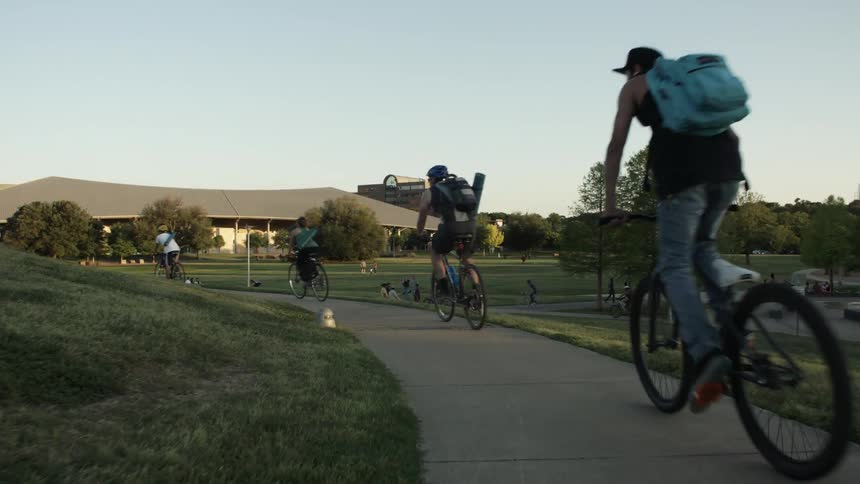 Bicyclists ride through a park
