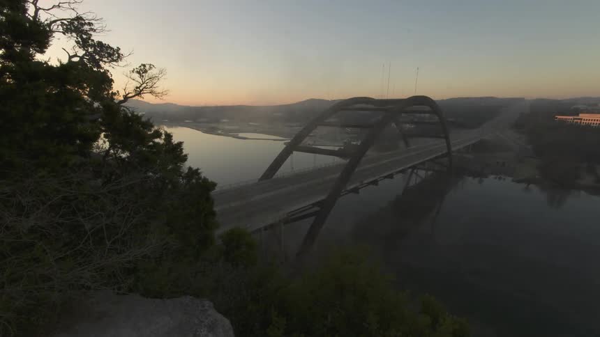 Headlights shine as traffic moves across a bridge