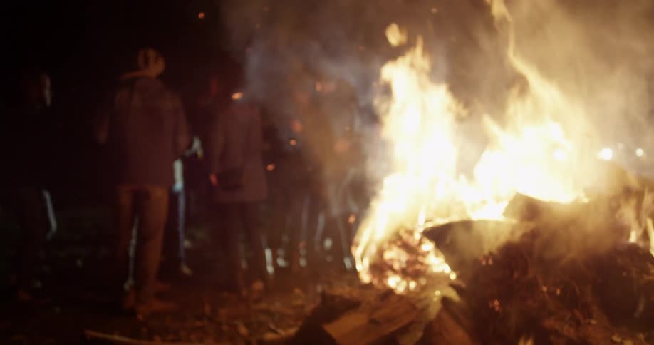 People are dancing around a fire