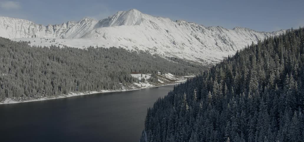 River separates tree and snow covered mountains