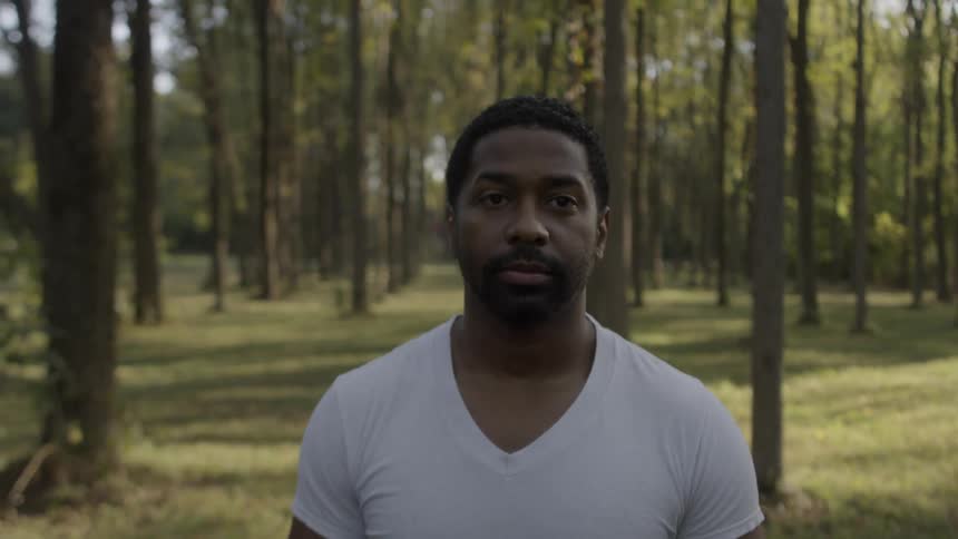 A man walks through trees