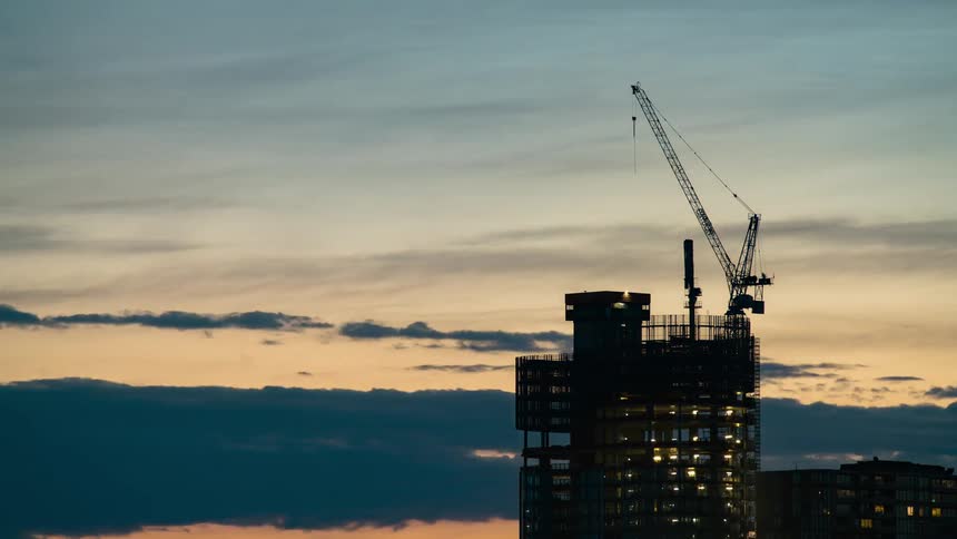 Sunset timelapse of a crane on top of a skyscraper