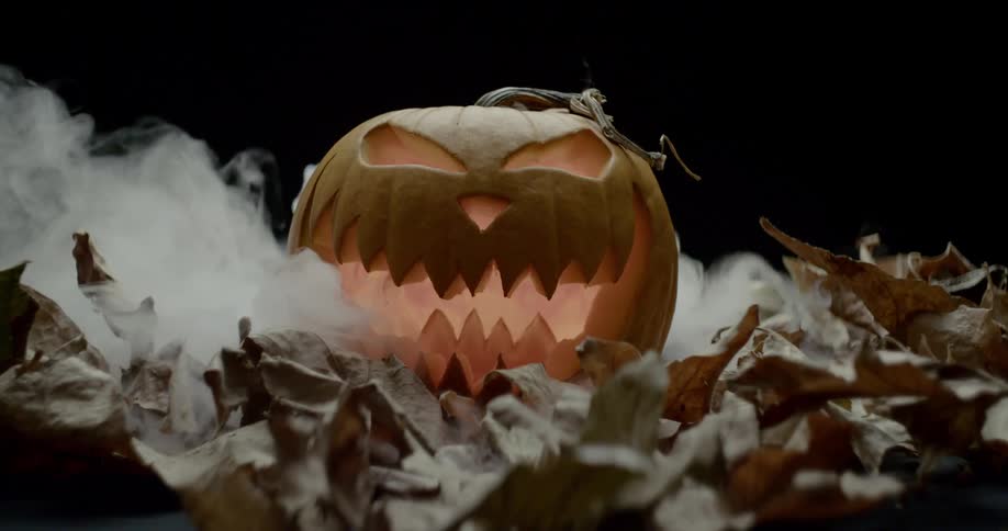 Smoke billows behind a jack o lantern