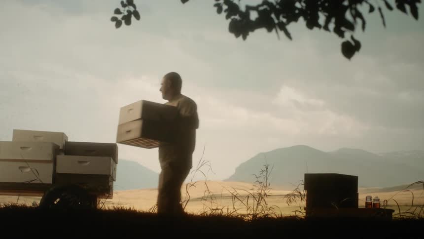 A man carries bins from one side to another
