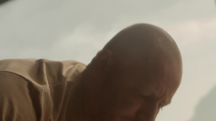 A man picks up two crates from the ground