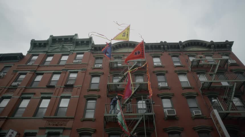 Multiple different flags in the wind on a building fire escape