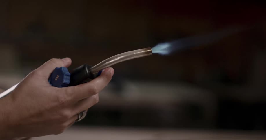 A person starting up a blowtorch