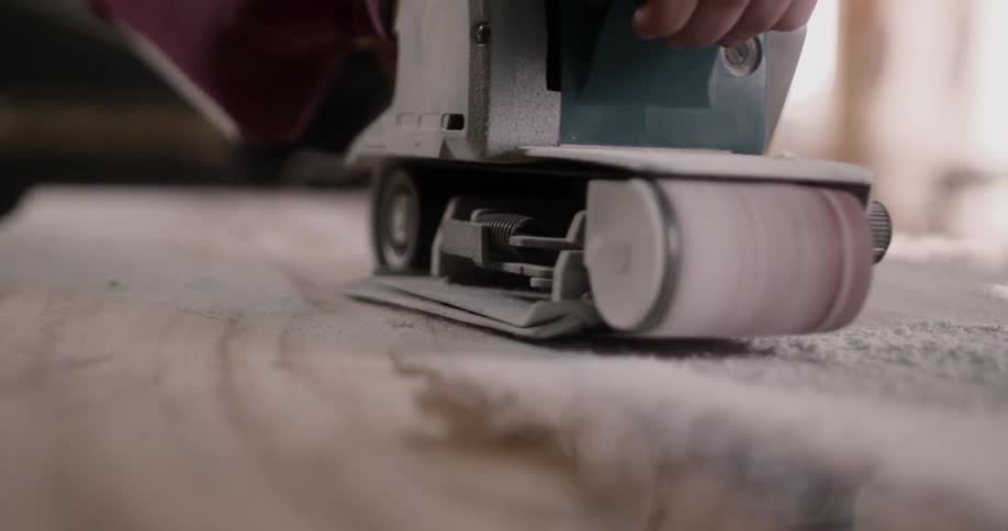 Craftsman sanding wood with power tool
