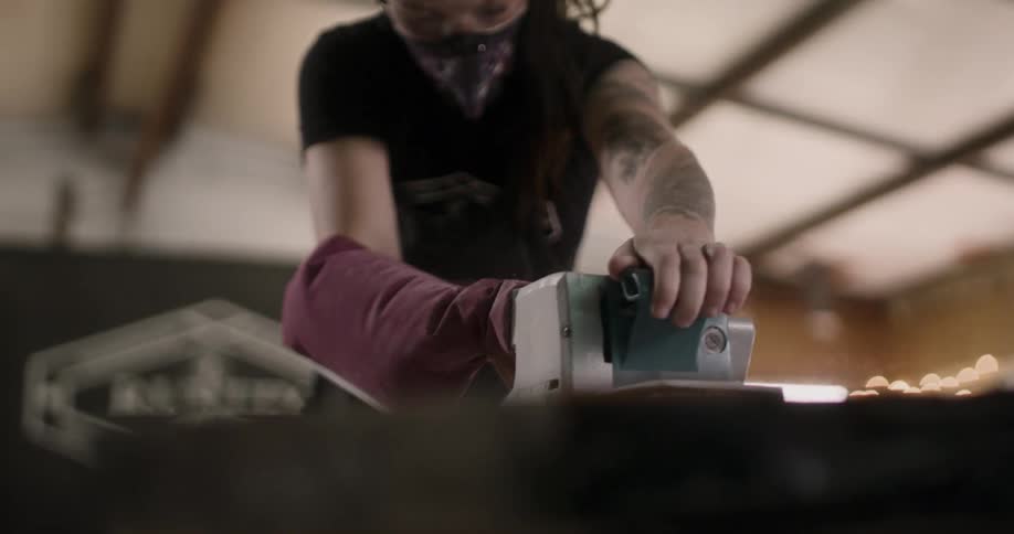 A woman sanding a board