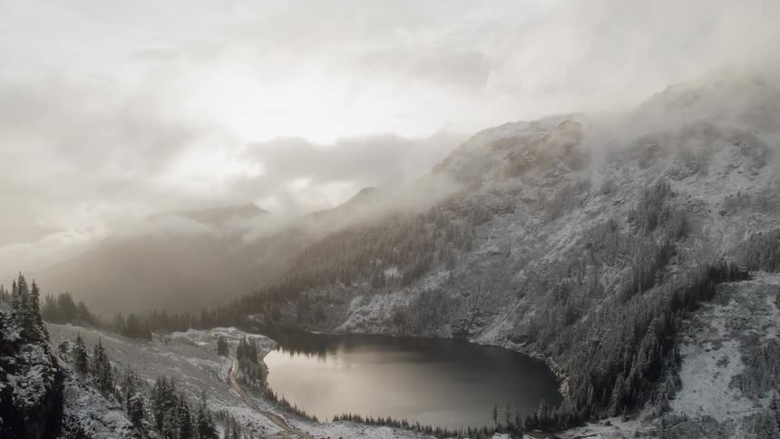 Snow falling around a mountain lake
