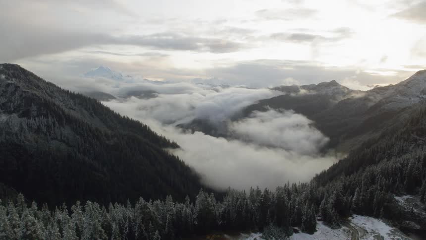 Aerial view of a lake covered by clouds in the mountains