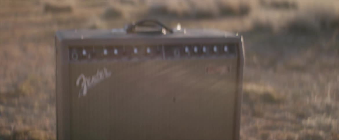 Fender guitar amp outdoors on flatland at sunset