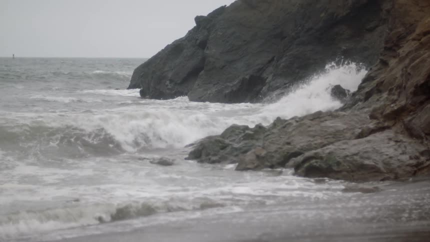 Waves crashing on the rocks on the shoreline at the beach