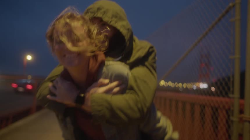 Woman and man walk along with a back hug