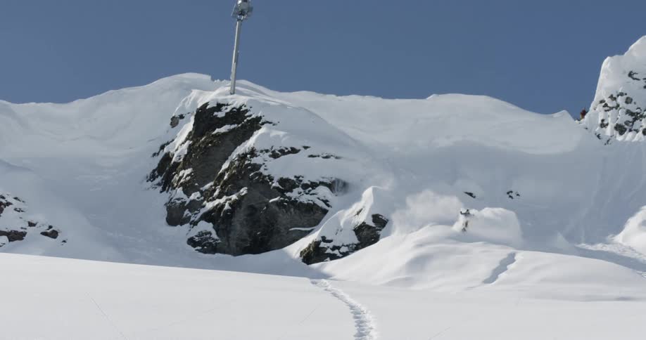 A skier descending a snow covered slope