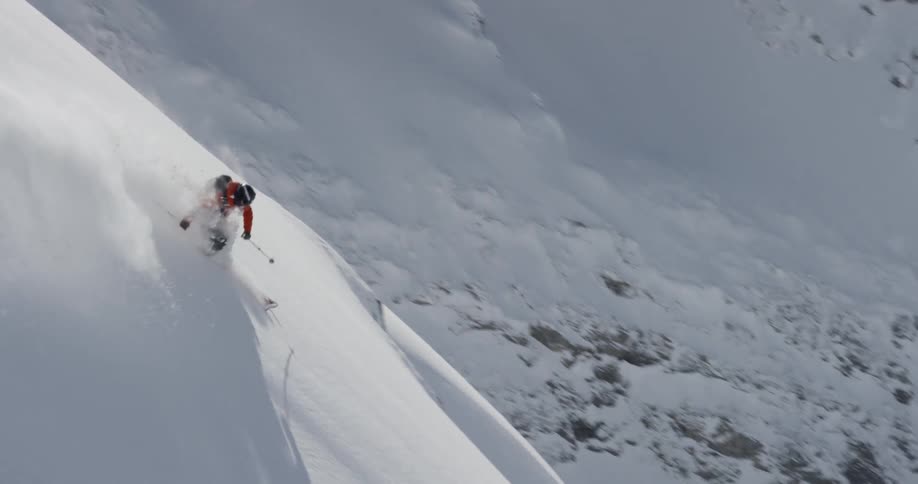 Person skiing through the snow down a steep mountain