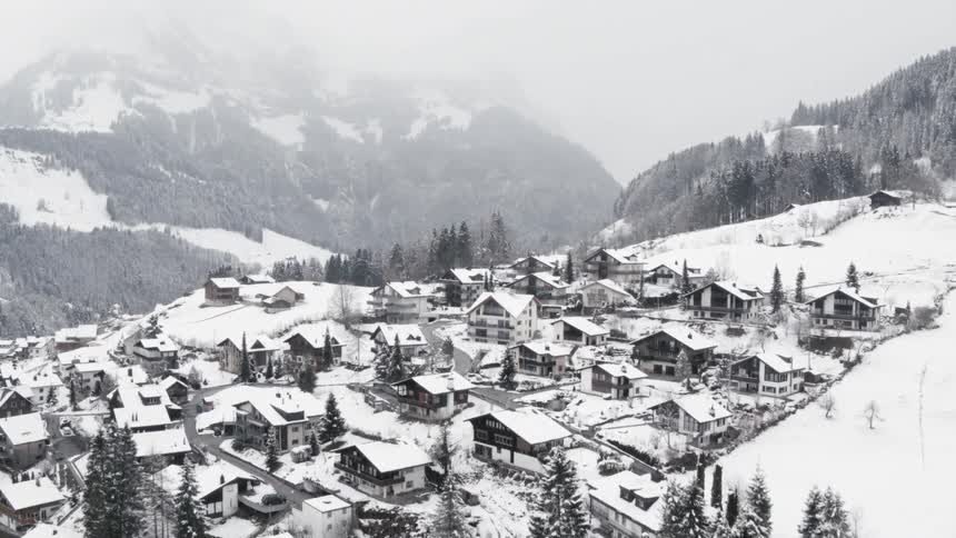 A picturesque village covered in snow and surrounded by mountains