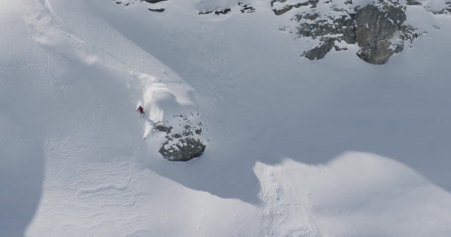 A skier races down a snowy mountain slope