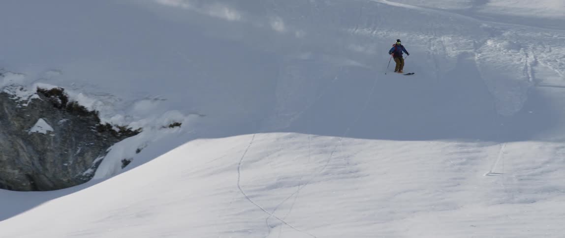 A person skis down a mountainside
