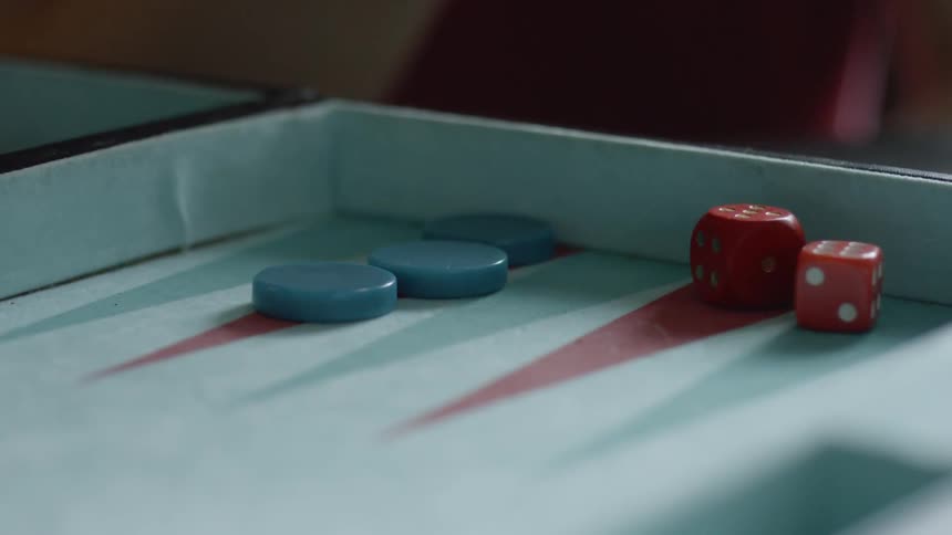 Two red dice being tossed on a backgammon board