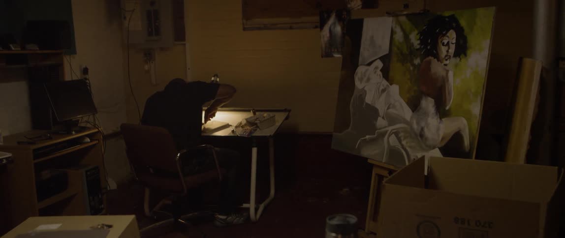 Artist works at drafting table in studio