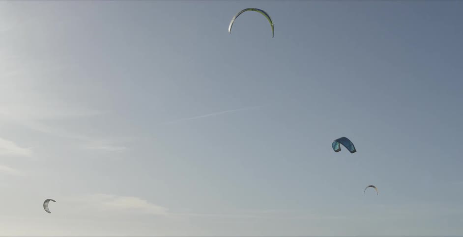 Kites in the lightly clouded blue sky