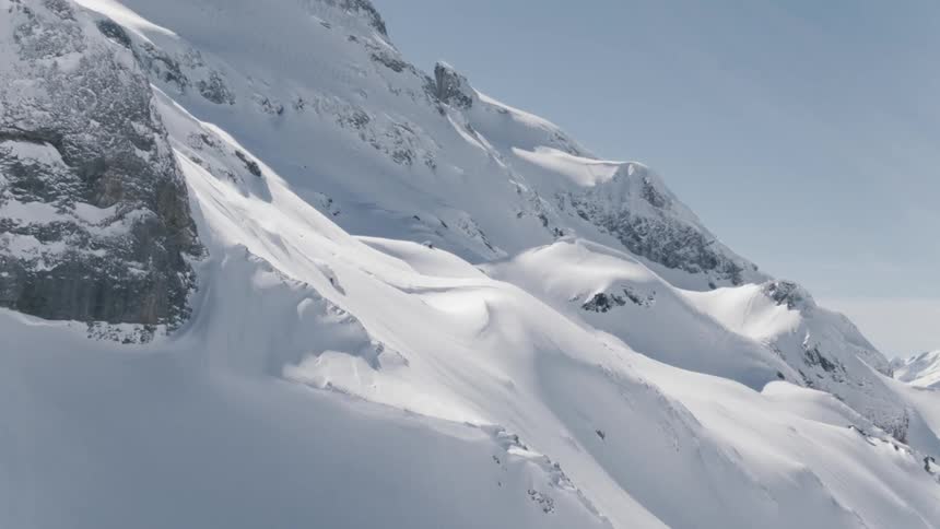 A person skies down a snowy mountain