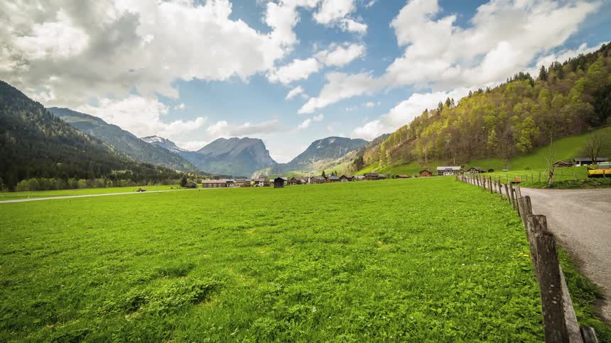 Clouds streaming over a farm in the mountains