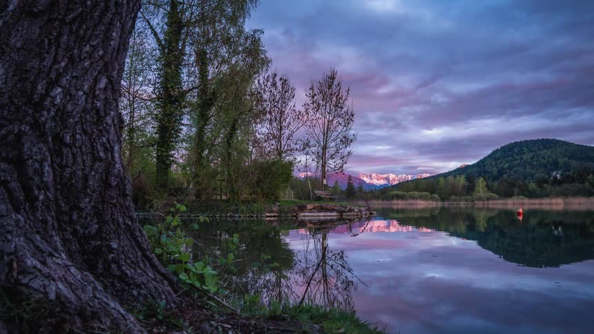A time lapse of man made canal surrounded by hills and trees on a cloudy day as a buoy floats on the surface of the water