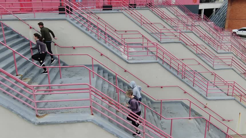 Four people running upstairs