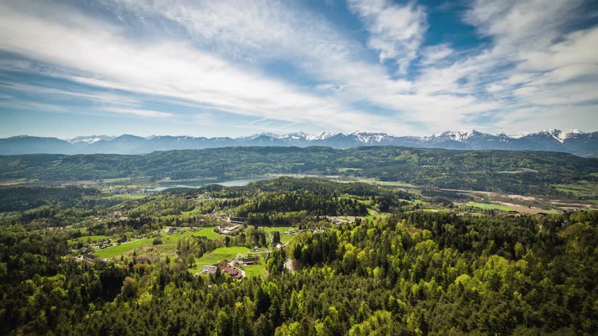 Clouds flow over estates and compounds surrounded by forest