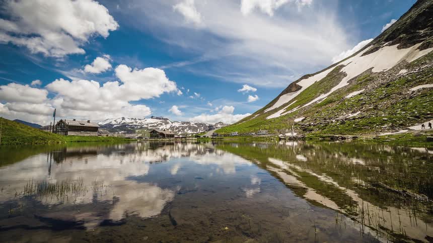 Clouds are reflected in lake between mountains