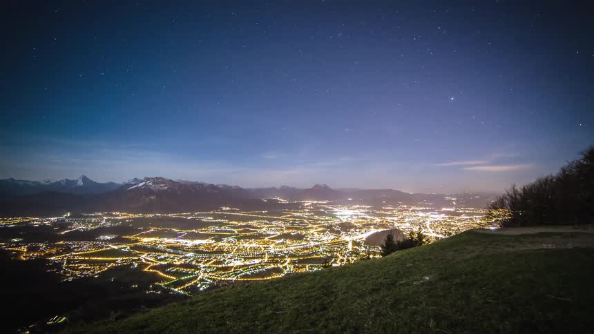 Lights glow in a city in a valley at night