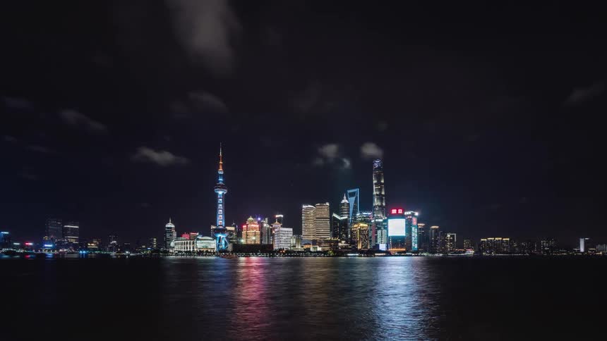 Brightly lit city bordering ocean at night