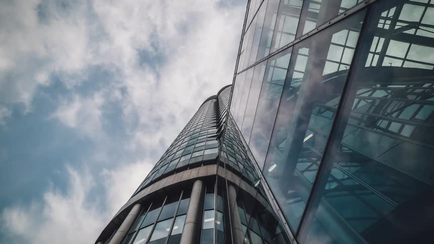 Clouds passing over a skyscraper covered in windows