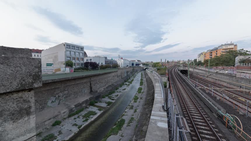 Trains and traffic move by on either side of a canal
