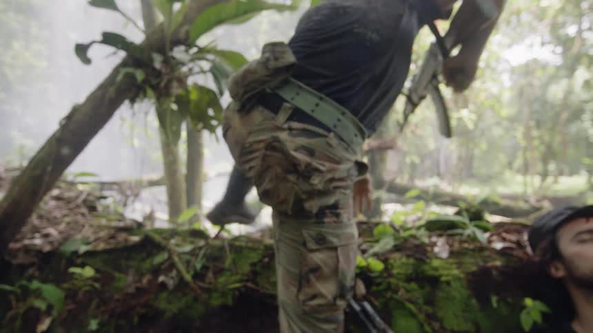 Men charge from shelter with weapons in forest