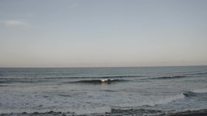 People with surfboards playing in the waves
