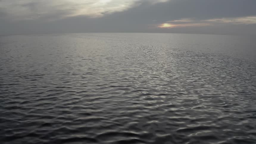 Aerial view of calm waters on the ocean at dusk