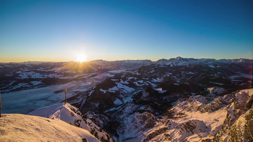 The sun rises over a snowy landscape