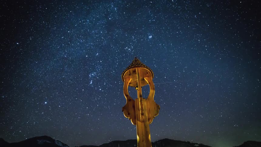 The golden spector points into space as stars fall and smoke swirls
