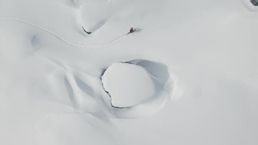 A person is hiking through a snow covered terrain in skis