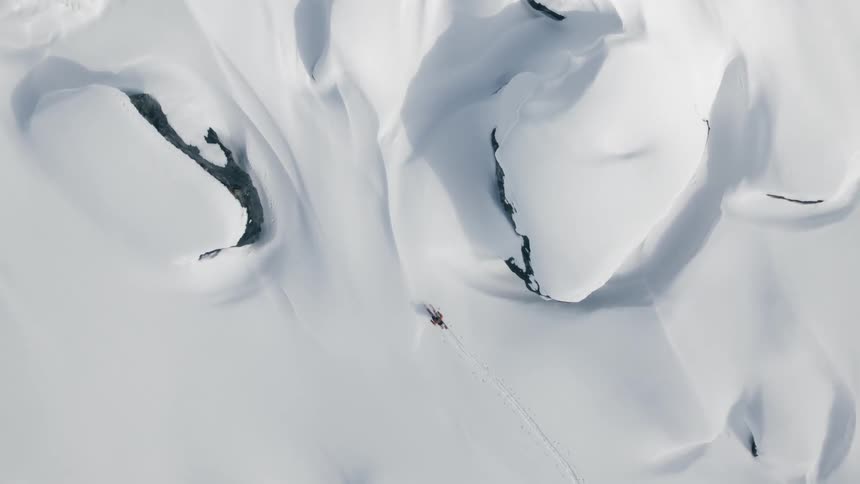 A skier treks across deep snow