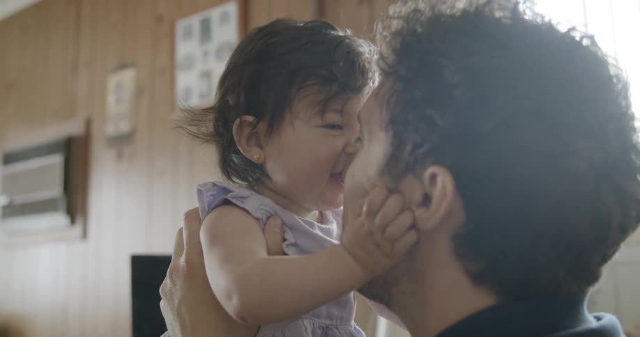 A man talks and smiles at his baby