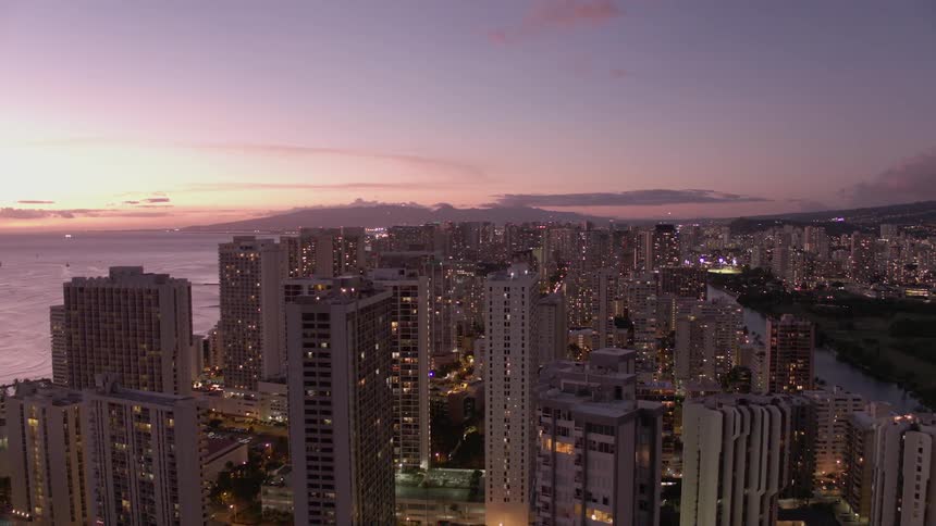 An aerial view of a large city on the coast at dusk
