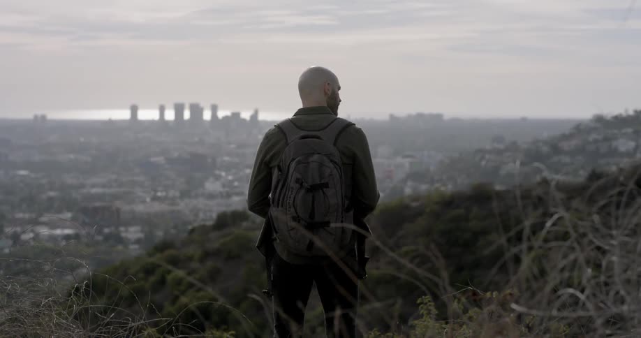 A man stands overlooking a city
