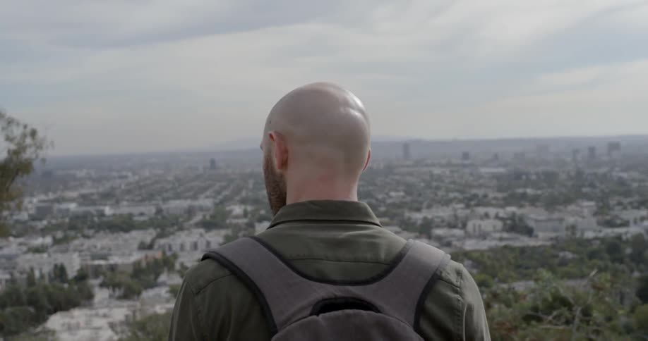 A bald caucasian man looking down at a city from a higher altitude