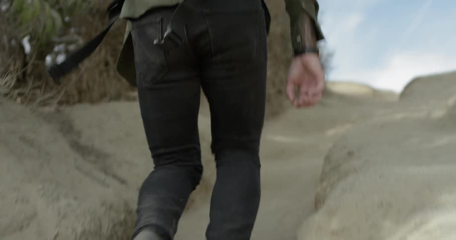 A man walks up a dirt pathway